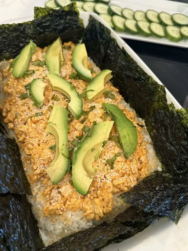 Zoom in of vegan sushi bake served with seaweed and cucumbers.